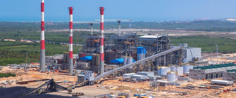 Complexo industrial com chaminés e esteira